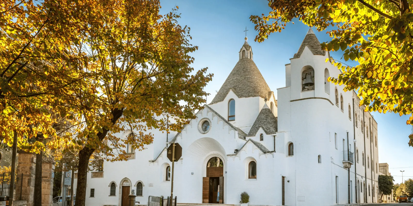Trullo-style church framed by autumn leaves