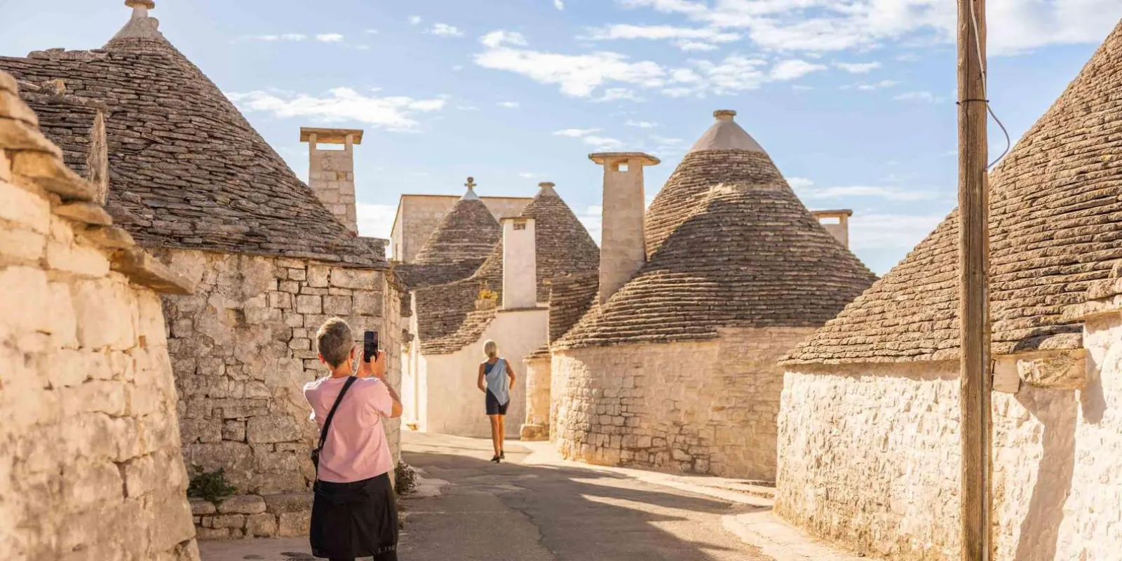 Visitor walking between traditional stone roofs
